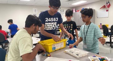 A team sorting through parts to build out their mechanism