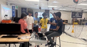 Mentors walking a team through their robot before the final competition