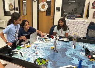 A team of campers programming their robot for the first time